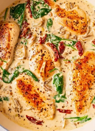 Delicious creamy Tuscan chicken served on a plate with herbs and tomatoes