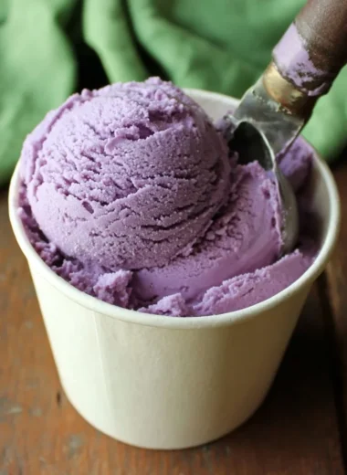 Bowl of homemade blueberry ice cream topped with fresh blueberries