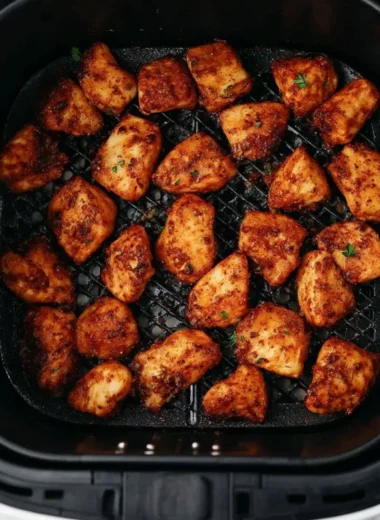 Crispy air fryer chicken bites served with dipping sauce on a plate