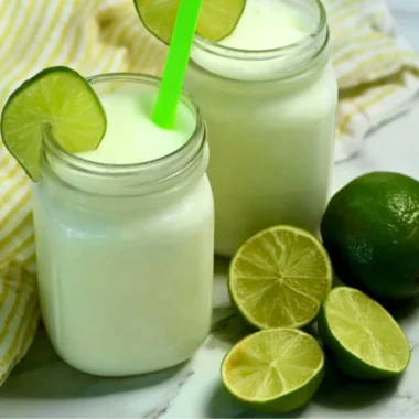 Brazilian Lemonade with Coconut in a glass, served on a tropical background