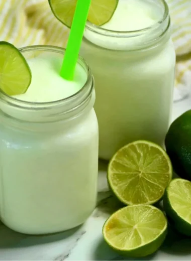 Brazilian Lemonade with Coconut in a glass, served on a tropical background