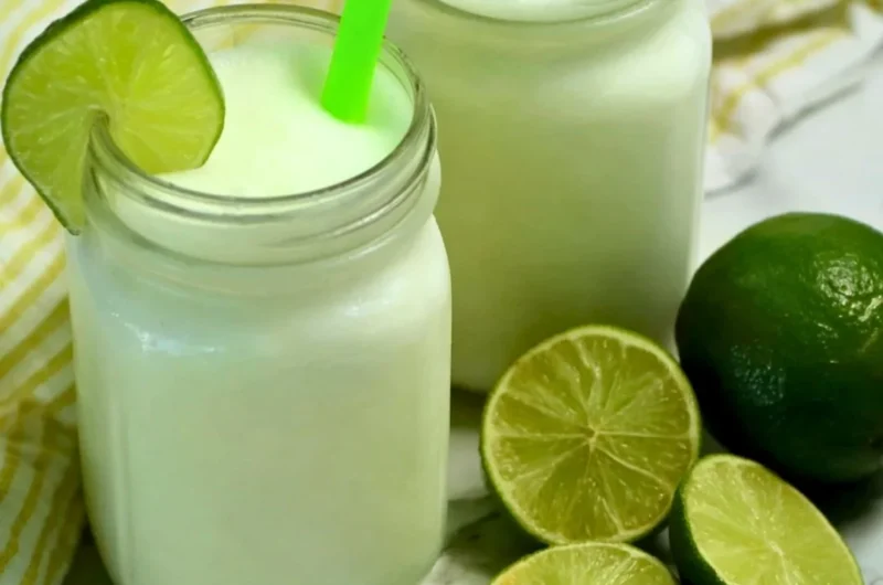 Brazilian Lemonade with Coconut in a glass, served on a tropical background