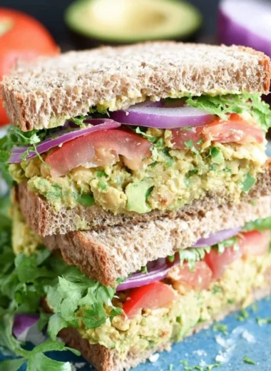 Chickpea avocado sandwich on a plate with fresh ingredients