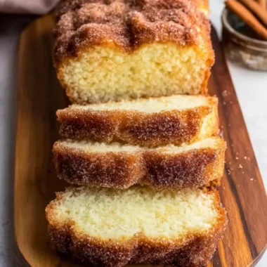 Freshly baked cinnamon sugar donut bread, sliced on a wooden board.