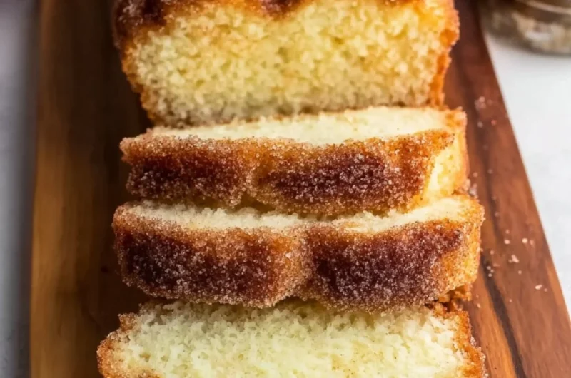 Freshly baked cinnamon sugar donut bread, sliced on a wooden board.