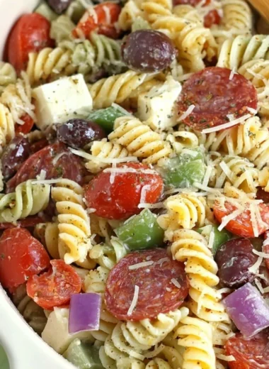 Bowl of classic pasta salad with fresh vegetables and dressing