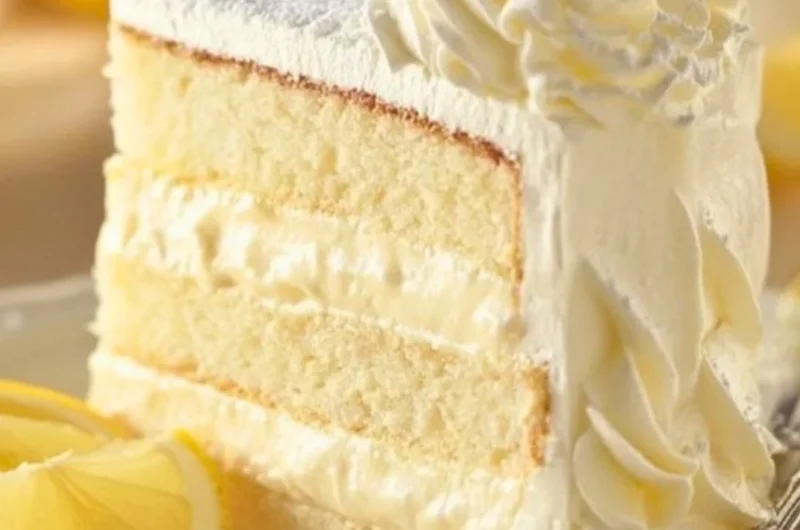 Slice of Italian Lemon Cream Cake with lemon zest and cream topping