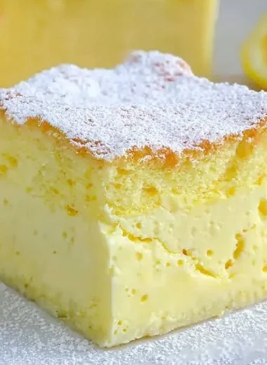Slice of cozy lemon custard cake with a lemon slice garnish on a plate