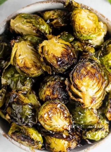 Crispy oven roasted Brussels sprouts topped with balsamic glaze on a plate.