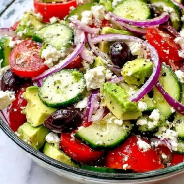 Refreshing Greek Salad with Avocado, tomatoes, cucumbers, and feta cheese.