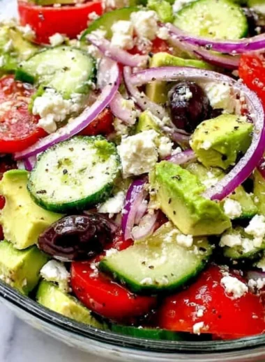 Refreshing Greek Salad with Avocado, tomatoes, cucumbers, and feta cheese.