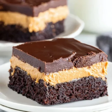 Layered Peanut Butter Brownies topped with chocolate and peanut butter swirl.