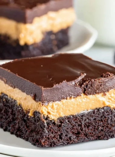 Layered Peanut Butter Brownies topped with chocolate and peanut butter swirl.