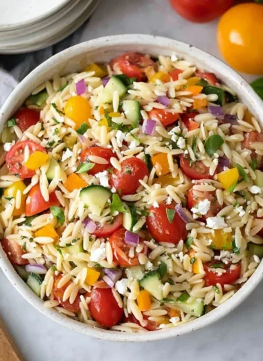 Colorful and fresh orzo salad with vegetables and dressing