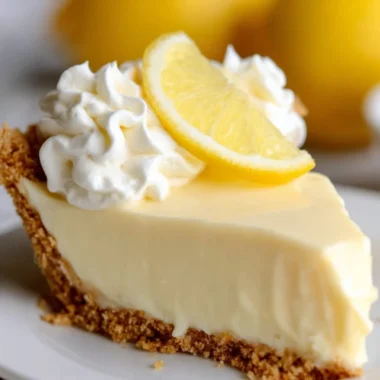 Delicious lemon pie topped with whipped cream and fresh lemon slices