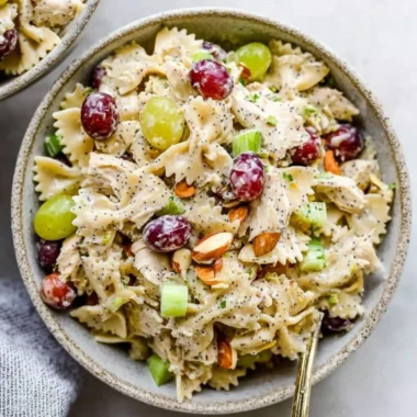Poppyseed Chicken Pasta Salad served in a bowl garnished with herbs