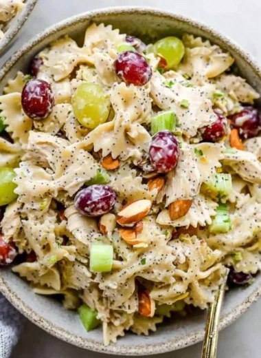Poppyseed Chicken Pasta Salad served in a bowl garnished with herbs