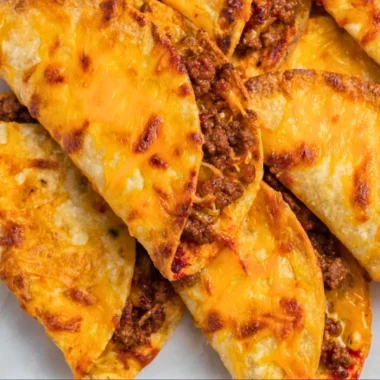 Delicious sheet pan tacos ready to serve with toppings on a baking tray.
