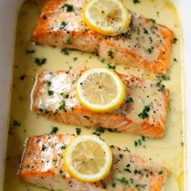 Salmon fillet topped with rich lemon cream sauce on a plate
