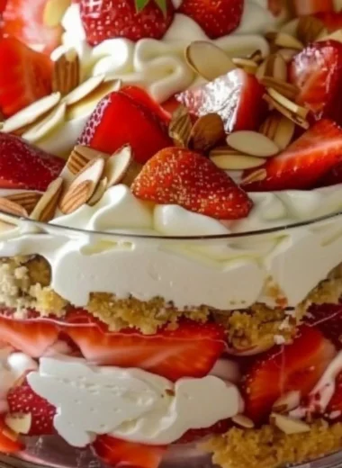 Strawberry cheesecake trifle with layers of cream, strawberries, and graham crackers