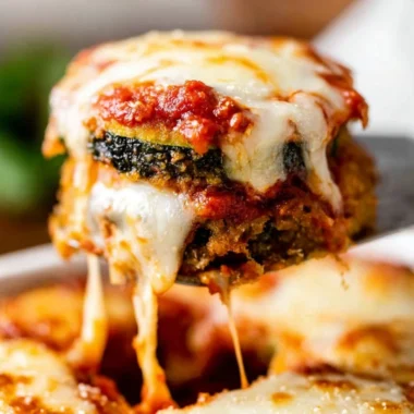 Delicious Zucchini Parmesan dish served on a plate with cheese and herbs