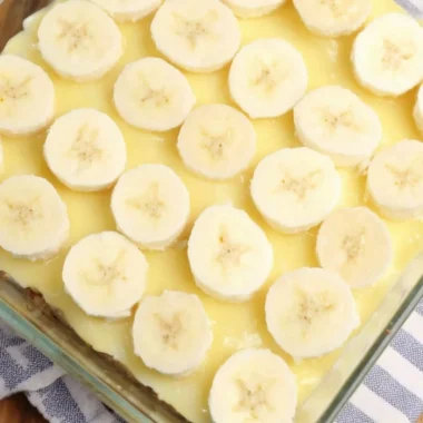 Delicious slice of Banana Pudding Poke Cake with creamy topping and banana slices
