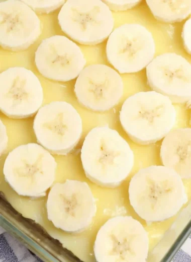 Delicious slice of Banana Pudding Poke Cake with creamy topping and banana slices