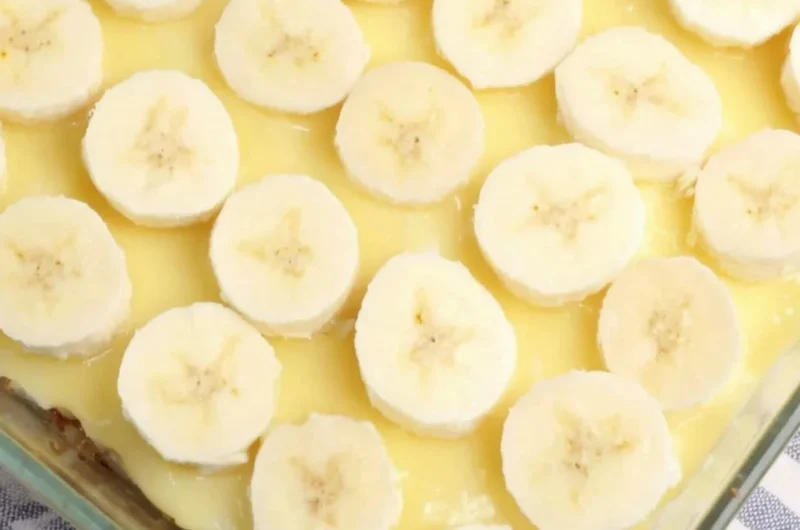 Delicious slice of Banana Pudding Poke Cake with creamy topping and banana slices
