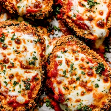 Crispy baked eggplant parmesan served with fresh herbs and marinara sauce.