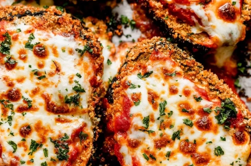 Crispy baked eggplant parmesan served with fresh herbs and marinara sauce.