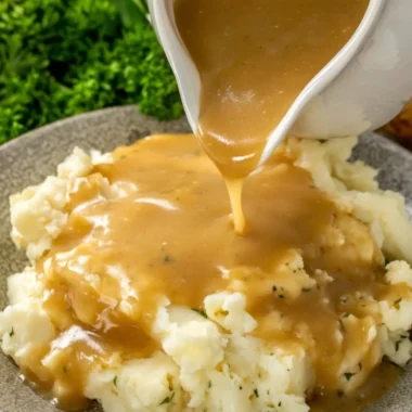 Bowl of easy homemade gravy drizzled over mashed potatoes.