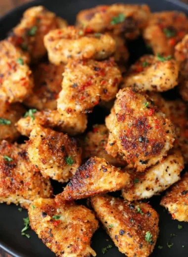 Delicious Garlic Parmesan Chicken Bites served on a plate with herbs.