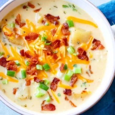 Bowl of slow cooker potato soup topped with green onions and bacon bits