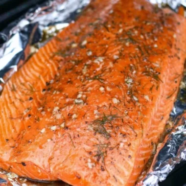 Smoked salmon dish garnished with herbs and lemon slices