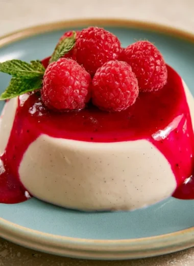 Delicious vegan vanilla panna cotta topped with fresh berries and mint leaves.