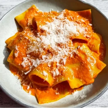 Delicious vodka pasta dish garnished with fresh basil and grated cheese