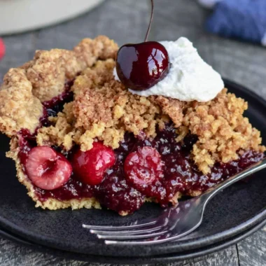 Delicious cherry crumb pie topped with golden crumble in a cozy kitchen setting