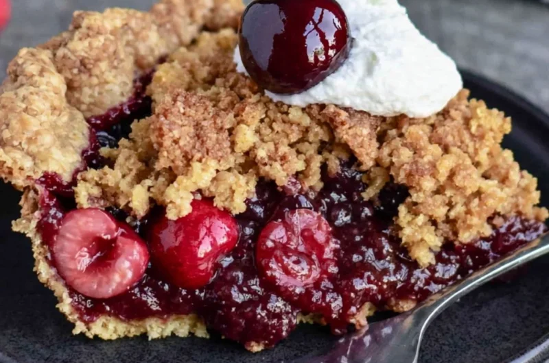 Delicious cherry crumb pie topped with golden crumble in a cozy kitchen setting