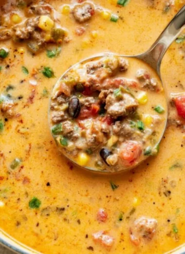 Bowl of cozy creamy taco soup topped with cheese and cilantro.