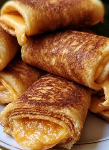 Plate of crispy cheesy roll ups, a tasty snack with melted cheese.