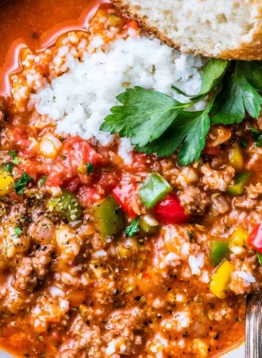 Bowl of delicious stuffed bell pepper soup garnished with fresh herbs.