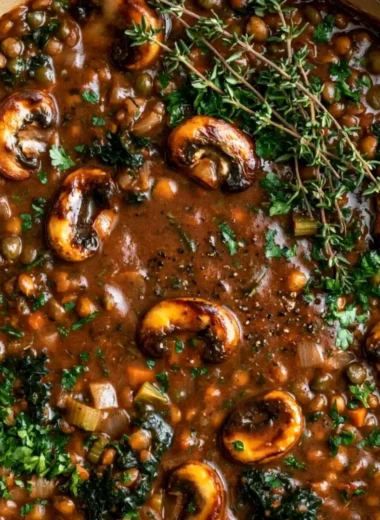 Bowl of hearty vegan lentil mushroom stew with fresh herbs and spices