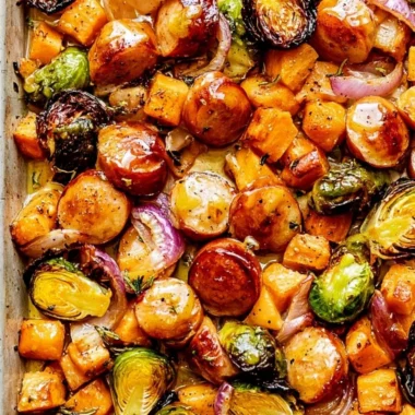 Sheet pan sausage with veggies drizzled in maple Dijon sauce for a family dinner.
