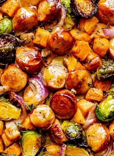 Sheet pan sausage with veggies drizzled in maple Dijon sauce for a family dinner.